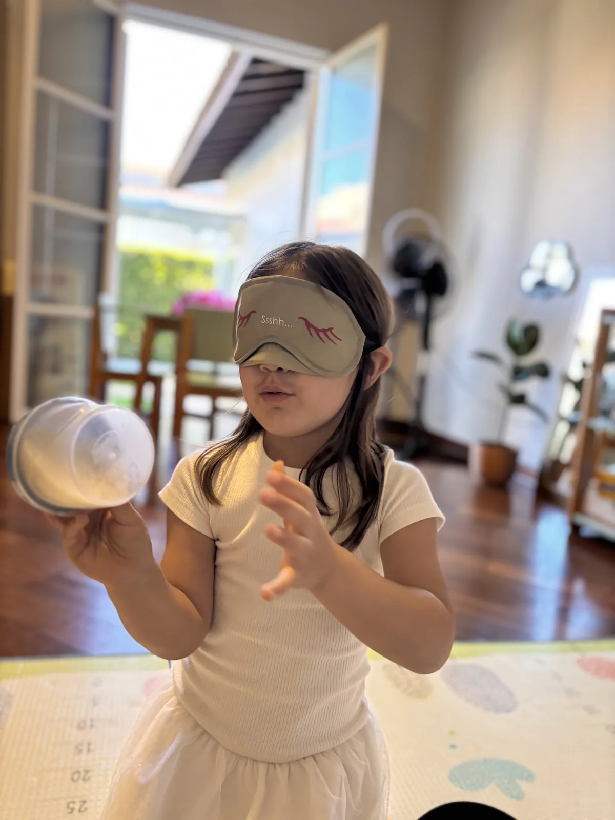 Criança de vendas nos olhos explorando um pote durante uma vivência no espaço da 4 Hands Be